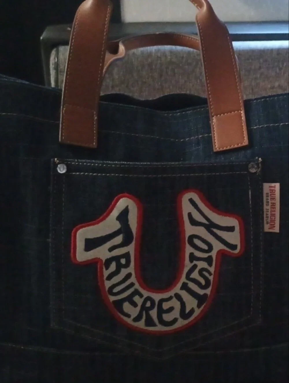True Religion Dark Denim Tote with Brown Leather Handles and Red Trim Logo